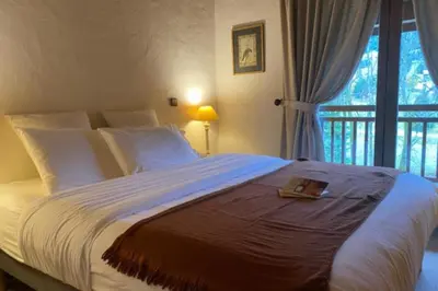 a bedroom with a large bed with a book on it at Stay in an ideal mountain chalet! in Megève