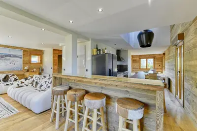 a kitchen and living room with a bar and a couch at Bright chalet in Combloux close to the slopes in Combloux