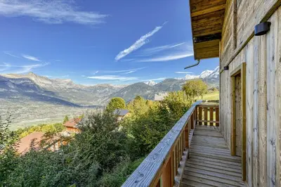 a wooden balcony with a view of mountains at Bright chalet in Combloux close to the slopes in Combloux