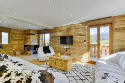 a living room with a couch and a tv at Bright chalet in Combloux close to the slopes in Combloux