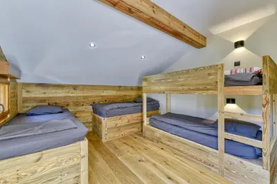 two bunk beds in a room with wooden floors at Bright chalet in Combloux close to the slopes in Combloux