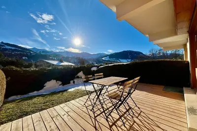 a wooden deck with a table and chairs on it at Bright apartment with terrace in Megève in Megève