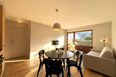 a living room with a table and a couch at Bright apartment with terrace in Megève in Megève