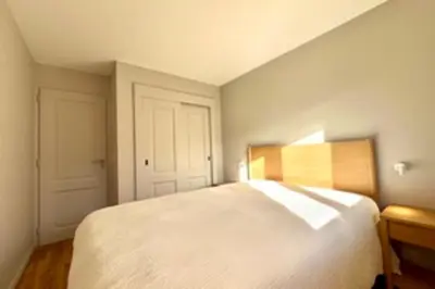 a bedroom with a large white bed with a wooden headboard at Bright apartment with terrace in Megève in Megève