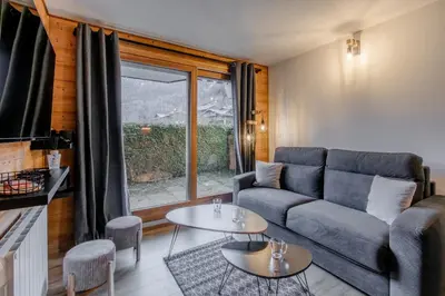 a living room with a couch and a table at Le Cocon du Prarion in Les Houches