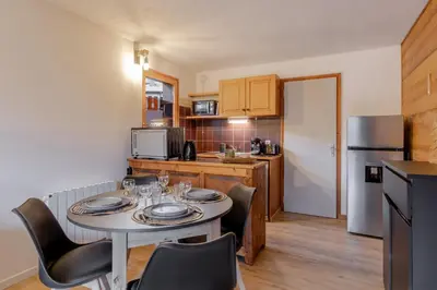 a small kitchen with a table and chairs in a room at Le Cocon du Prarion in Les Houches