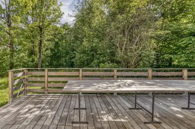 a picnic table on a wooden deck in front of a fence at Chalet 18 guests, 8 bedrooms, 5 bathrooms & Sauna! in Les Houches