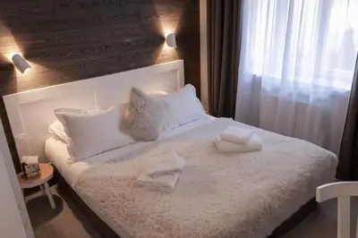 a bedroom with a white bed with two towels on it at Chalet 7CH Groupes Centre-ville Sauna in Chamonix-Mont-Blanc