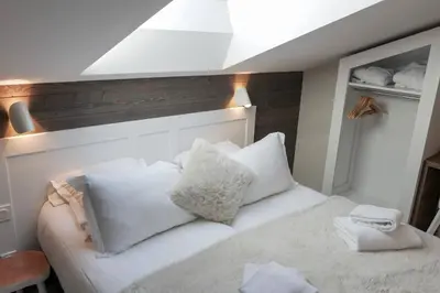 a bedroom with a white bed with white pillows at Chalet 7CH Groupes Centre-ville Sauna in Chamonix-Mont-Blanc