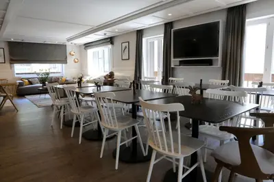 a dining room with tables and white chairs at Chalet 7CH Groupes Centre-ville Sauna in Chamonix-Mont-Blanc