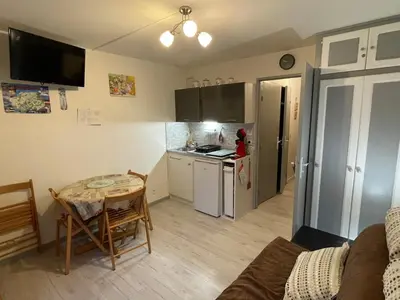 a living room with a table and a kitchen at Studio cosy au centre de Samoëns pour 4 pers, animaux admis - FR-1-629-153 in Samoëns