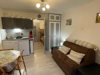 a living room and kitchen with a couch and a table at Studio cosy au centre de Samoëns pour 4 pers, animaux admis - FR-1-629-153 in Samoëns
