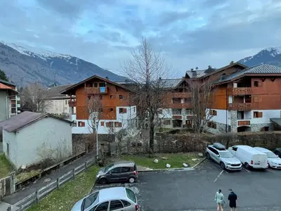 a parking lot with cars parked in front of a building at Studio cosy au centre de Samoëns pour 4 pers, animaux admis - FR-1-629-153 in Samoëns