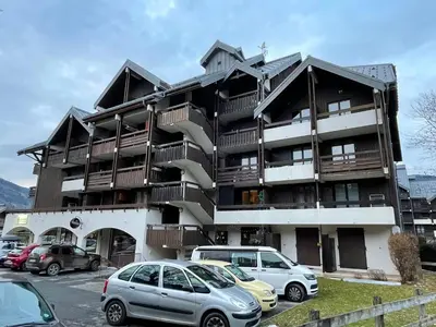 a building with cars parked in a parking lot at Studio cosy au centre de Samoëns pour 4 pers, animaux admis - FR-1-629-153 in Samoëns