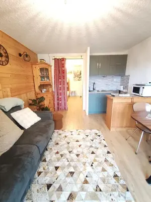 a living room with a couch and a kitchen at Le Nid d'Amélie Studio 4 people mountain view in Combloux