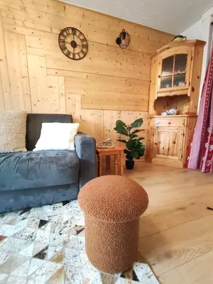 a living room with a couch and a stool at Le Nid d'Amélie Studio 4 people mountain view in Combloux