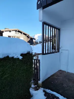 a door to a house with snow on the ground at Le Nid d'Amélie Studio 4 people mountain view in Combloux