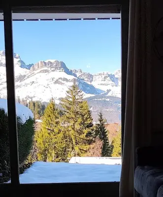 a view of a snowy mountain from a window at Le Nid d'Amélie Studio 4 people mountain view in Combloux