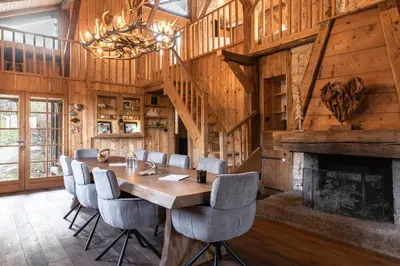 a dining room with a table and chairs and a fireplace at Chalet Paris Mont-Blanc Luxe et authenticite in Saint-Gervais-les-Bains