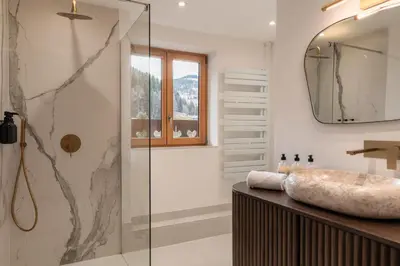 a bathroom with a sink and a glass shower at Chalet Paris Mont-Blanc Luxe et authenticite in Saint-Gervais-les-Bains