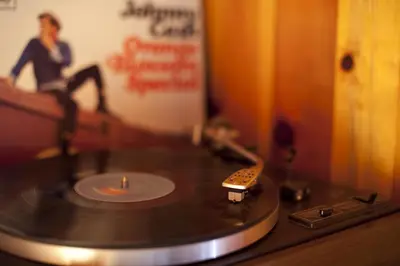 a vinyl record on a table with a person sitting on a couch at Marmotte Mountain Retreat in Chamonix-Mont-Blanc