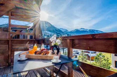 a chair on a deck with a view of a mountain at Discreet Alpine Luxury Suite Art of Living in Megève in Megève