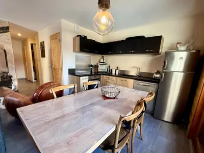a kitchen with a wooden table and a refrigerator at Appartement lumineux 3 pièces proche des pistes avec WiFi et parking - FR-1-572-343 in Arâches-la-Frasse