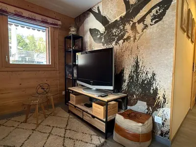 a living room with a television on a wall at Appartement lumineux 3 pièces proche des pistes avec WiFi et parking - FR-1-572-343 in Arâches-la-Frasse
