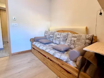 a couch sitting in the corner of a room at Appartement lumineux 3 pièces proche des pistes avec WiFi et parking - FR-1-572-343 in Arâches-la-Frasse