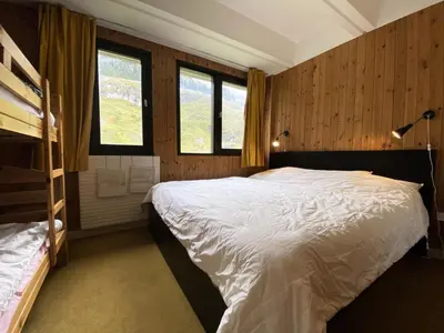 a bedroom with a large bed and two windows at Résidence Aldébaran - maeva Home - Appartement au pied des pistes 2 pièces 6 personnes - Budget MAE-9763 in Flaine