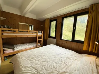 a bedroom with a bed and two bunk beds at Résidence Aldébaran - maeva Home - Appartement au pied des pistes 2 pièces 6 personnes - Budget MAE-9763 in Flaine