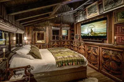 a bedroom with a large bed with a painting on the wall at Chalet La Renarde in Chamonix-Mont-Blanc