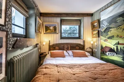 a bedroom with a large bed and a painting on the wall at Chalet La Renarde in Chamonix-Mont-Blanc