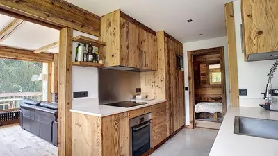 a kitchen with wooden cabinets and a sink and a stove at Riante Colline Edelweiss - PROCHE CENTRE 3 chambres- balcon in Megève