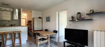 a kitchen with a table and a tv in a room at Rochebrune, proche piste rr6171 in Megève