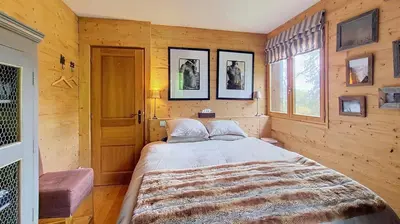 a bedroom with a large bed in a wooden room at Les Perchets - PROCHE CENTRE - 2 chambres in Megève