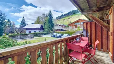 a red chair sitting on a deck with a view at Primeveres 1 - JAILLET - PROCHE CENTRE - in Megève