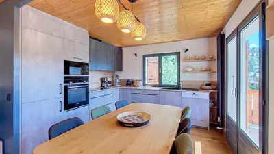 a kitchen with a wooden table and a dining room at Saint Michel - JAILLET - grand 3 chambres in Megève