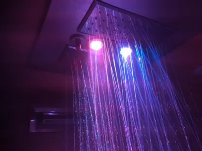 a pink and blue light hanging from a shower curtain at Chamonix Holiday Cromotherapy Apartment 1 in Chamonix-Mont-Blanc