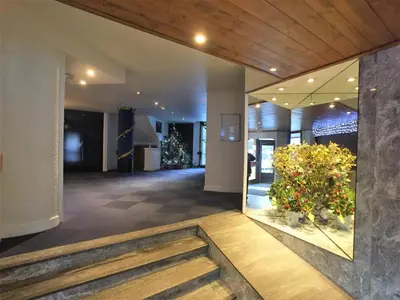 a lobby with a staircase and flowers in a building at Chamonix Holiday Cromotherapy Apartment 1 in Chamonix-Mont-Blanc