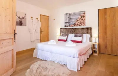 a bedroom with a bed with two towels on it at Catered Chalet Les Clochettes in Megève