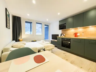 a hotel room with two beds and a kitchen at Studio exceptionnel, tout équipé face à l'aiguille du midi in Chamonix-Mont-Blanc