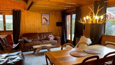 a living room with a couch and a table at Red Fir Chalet in Megève
