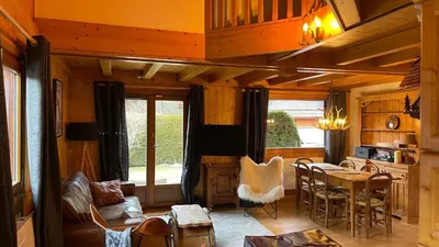 a living room with a table and a dining room at Red Fir Chalet in Megève