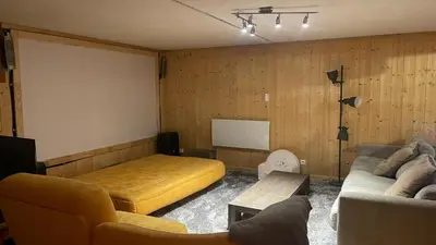 a living room with a couch and a bed at Red Fir Chalet in Megève