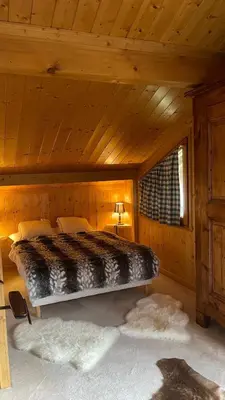 a bedroom with a bed in a wooden cabin at Red Fir Chalet in Megève