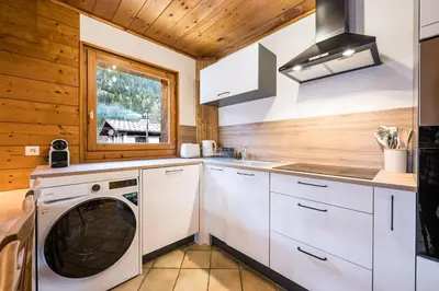 a kitchen with a washing machine and a window at Renovated Apartment 7p Argentière - Close to Slopes! in Chamonix-Mont-Blanc