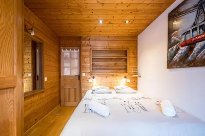 a bedroom with a bed in a wooden room at Renovated Apartment 7p Argentière - Close to Slopes! in Chamonix-Mont-Blanc
