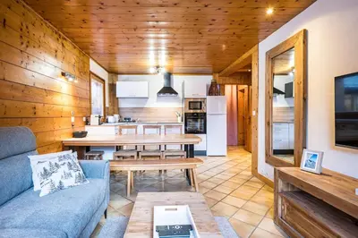 a living room with a blue couch and a table at Renovated Apartment 7p Argentière - Close to Slopes! in Chamonix-Mont-Blanc