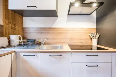 a kitchen with white cabinets and a sink at Renovated Apartment 7p Argentière - Close to Slopes! in Chamonix-Mont-Blanc